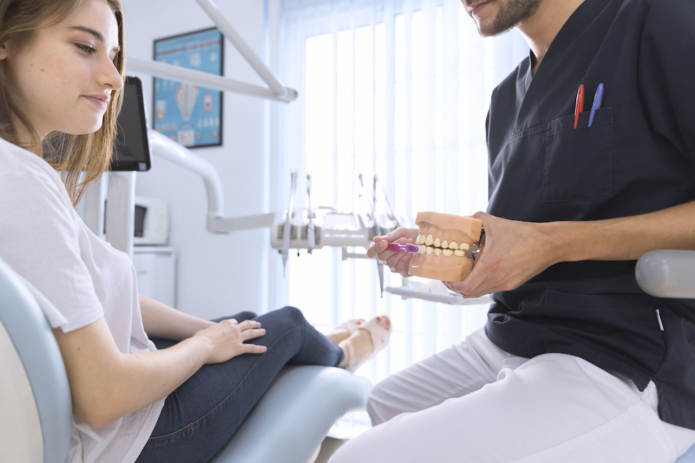 стоматолог показывает пациенту
